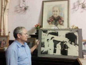 Ông Trịnh Cần Chính bên bức ảnh chụp cha, mẹ và bà nội trong "Tuần Lễ Vàng". Ảnh: Diệu Bình/Vietnamnet