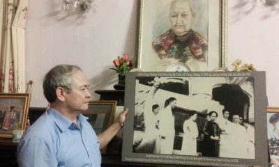 Ông Trịnh Cần Chính bên bức ảnh chụp cha, mẹ và bà nội trong "Tuần Lễ Vàng". Ảnh: Diệu Bình/Vietnamnet