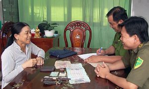 Bà Nhỡ cùng số tài sản nhặt được tại cơ quan công an. Ảnh: Vũ Chiến
