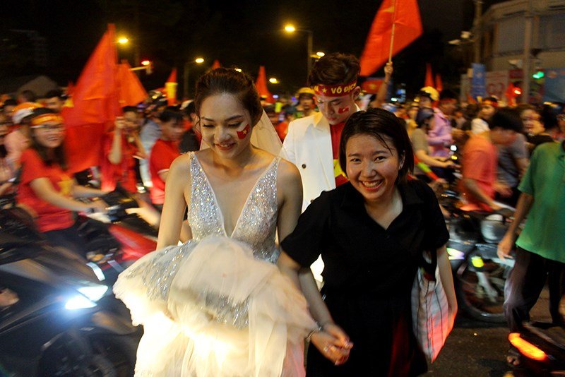 Cô dâu xinh đẹp rạng ngời còn dán cả cờ đỏ sao vàng lên mặt.