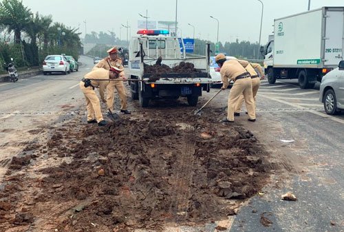 Tổ công tác của Đội Cảnh sát giao thông số 15 huy động xe chuyên dụng để dọn đống đất đổ giữa đường Võ Văn Kiệt. Ảnh: Sơn Dương