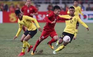 Quang Hải (đỏ) đi bóng qua các cầu thủ Malaysia ở chung kết lượt về tại Mỹ Đình. 