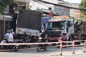 Sau khi nổ lốp, xe tải lao sang đường rồi tông sập hai nhà dân ở huyện Củ Chi, tài xế kẹt trong cabin.