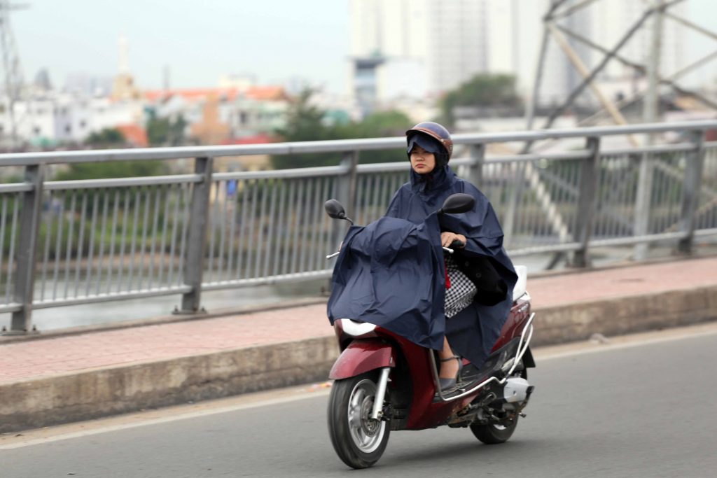 Nhiều người mặc áo mưa để giữ ấm cơ thể khi trời Sài Gòn se lạnh.