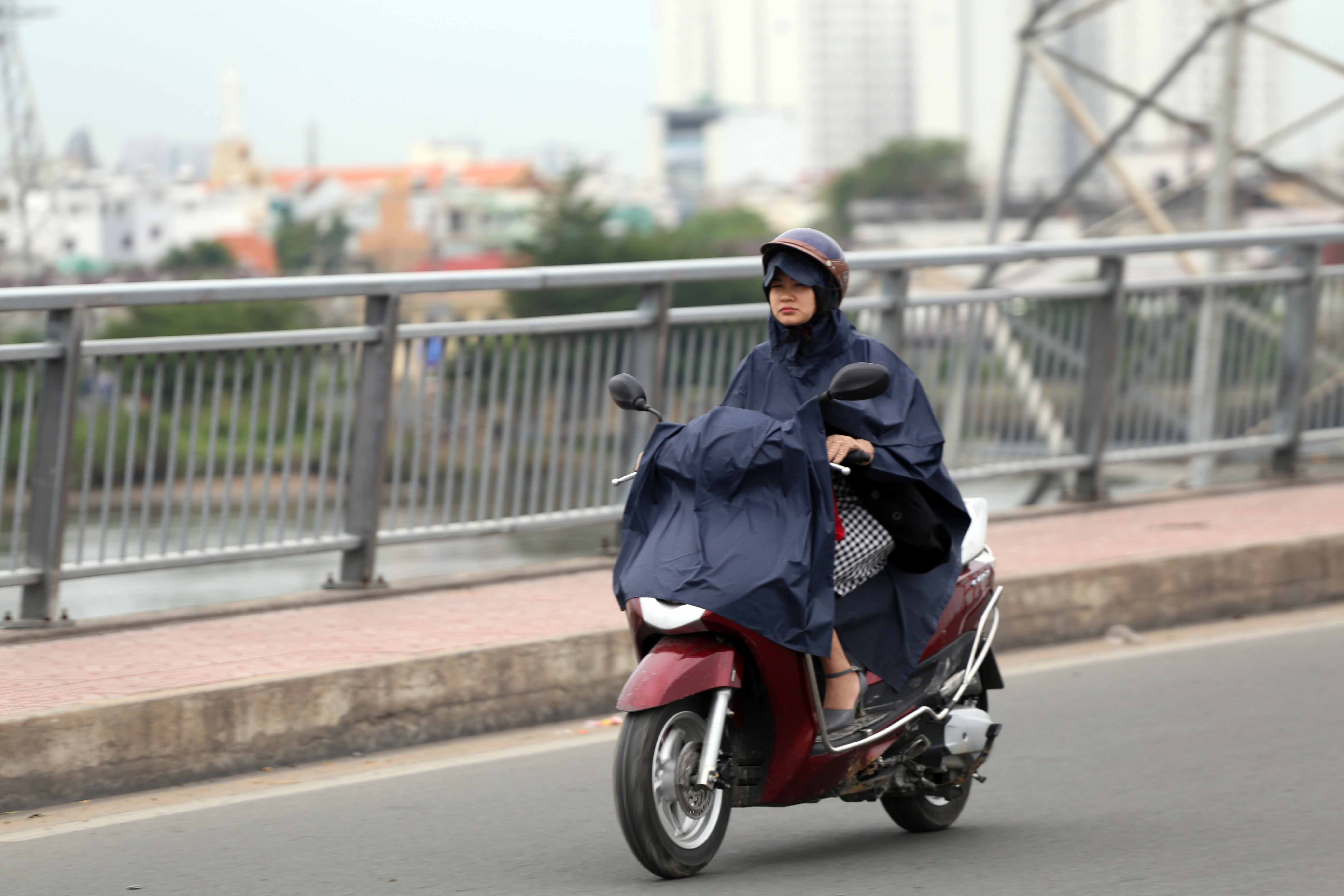 Nhiều người mặc áo mưa để giữ ấm cơ thể khi trời Sài Gòn se lạnh.