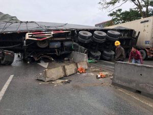 Hiện trường vụ tai nạn khiến chiếc xe container lật nghiêng giữa đường.