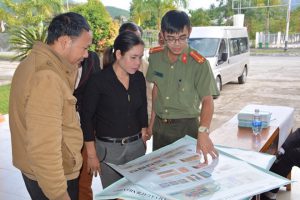 Lực lượng chức năng đang hướng dẫn người dân phân biệt tiền giả và tiền thật. (Ảnh: Bộ Công an)