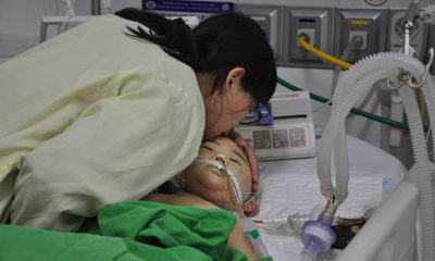 Nụ hôn tiễn biệt của người mẹ trước khi bác sĩ nhận giác mạc của bé Mai Reon. Ảnh: Hoàng Nguyễn.