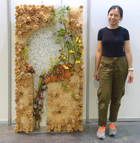 Quỳnh Giang bên bức tường hoa đoạt giải vàng tại lễ hội hoa năm 2018 của Malaysia. Ảnh: NVCC.