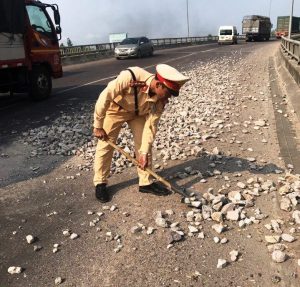 CSGT Bình Định mượn xẻng từ nhà dân để dọn dẹp đá rơi vãi trên đường.CSGT Bình Định mượn xẻng từ nhà dân để dọn dẹp đá rơi vãi trên đường.