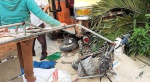 Hiện trường vụ tai nạn cho thấy xe máy điện, xe lôi nằm dưới gầm trước xe khách.