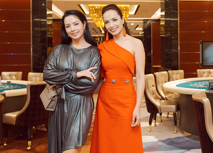 Cựu người mẫu Thúy Hằng chuộng trang phục gam trầm trong khi em gái song sinh Thúy Hạnh rực rỡ với váy và phụ kiện màu cam.