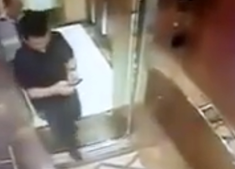 Ông Nguyễn Hữu Linh dán mắt vào điện thoại trước khi thấy bé gái trong thang máy.