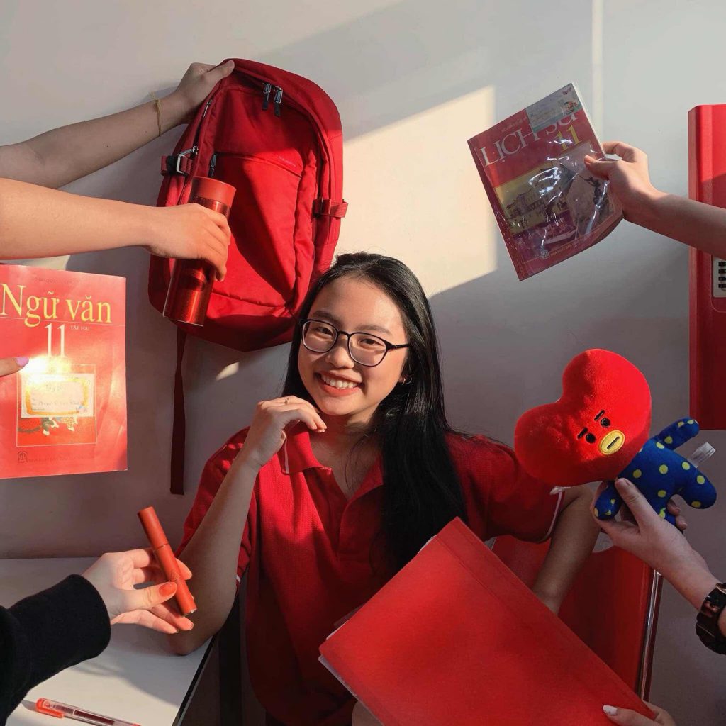 Phương Mỹ Chi là người phù hợp nhất với "trend" này. Cô học sinh lớp 11 diện chiếc áo đồng phục đỏ, xung quanh là son, sách giáo khoa, ba lô, bình nước cùng màu. 