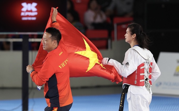 Phạm Thị Thu Hiền cùng với HLV của mình ăn mừng tấm HC vàng môn taekwondo sau khi giành chiến thắng 11-9 trước võ sĩ người Campuchia ở chung kết hạng dưới 62 kg nữ.