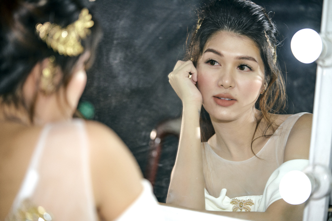 Hoa hậu chăm chút dung nhan, ngắm mình trong gương trước khi lên sàn diễn.