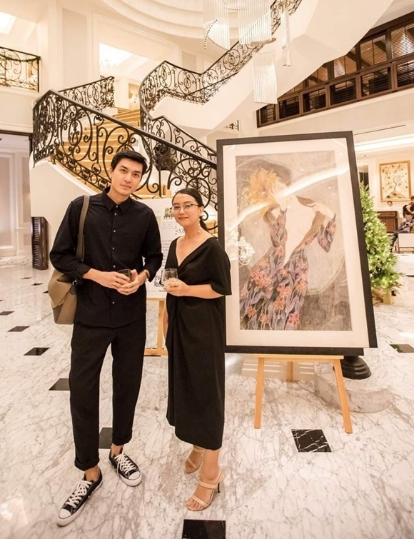 Người mẫu Quang Đại (trái) cũng có mặt tại hôm khai mạc chương trình. Anh dành thời gian thưởng thức các sản phẩm nghệ thuật tại đây và chụp hình kỷ niệm bên bức tranh tâm đắc.