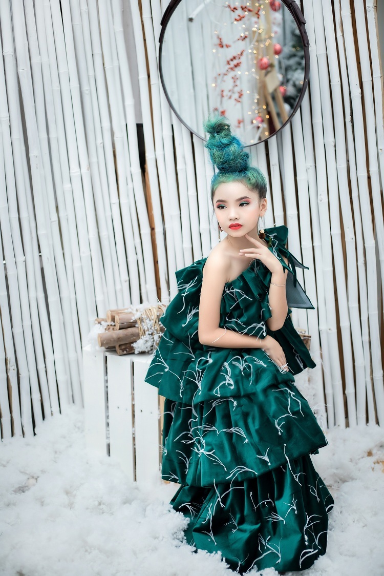 Cây thông là biểu tượng không thể thiếu của Giáng sinh. Chiếc váy dạ hội hình cây thông độc đáo được thể hiện ấn tượng qua diễn xuất của mẫu nhí Nguyễn Phương Linh.