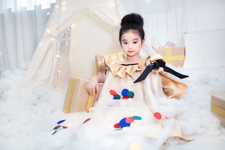 Bộ cánh xếp ly màu vàng được trang trí thêm lớp lụa trong suốt đính kết các họa tiết chấm bi nhiều màu sắc để tạo điểm nhấn thú vị. 