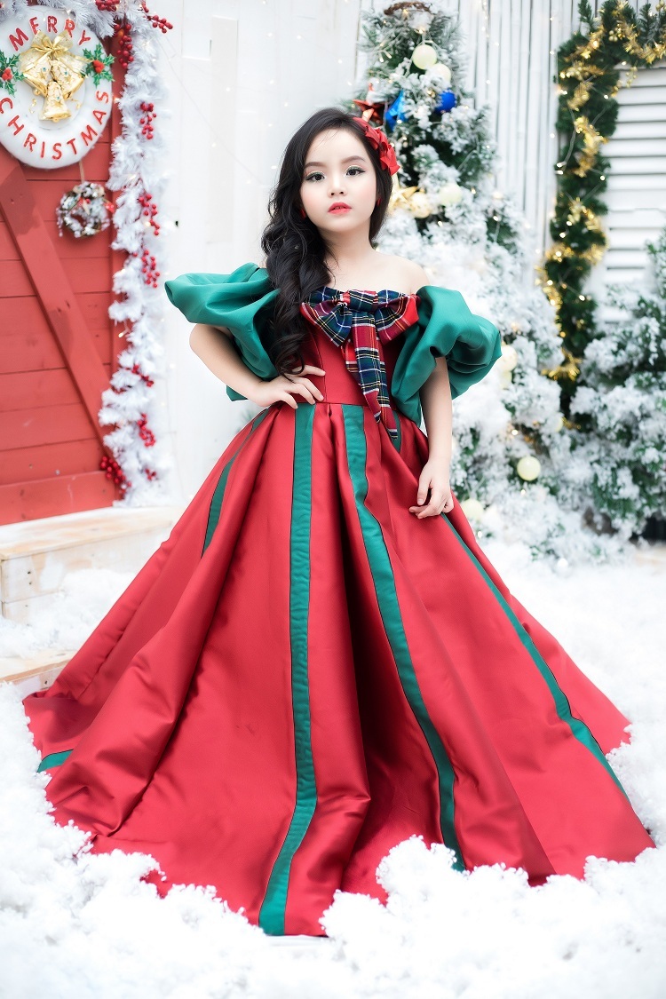 Người mẫu nhí Kitty Thiên Kim đã chọn chiếc đầm dạ hội lộng lẫy với sắc đỏ và xanh, gam màu đặc trưng của mùa giáng sinh, để hóa thân thành một nàng công chúa bước ra từ thế giới cổ tích.