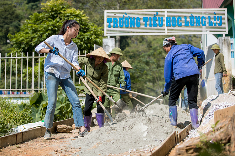 Hoa hậu Thùy Linh (trái) cùng người dân xây đường. Ảnh: SV.