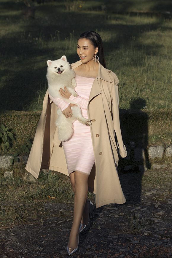 Chiếc áo măng tô màu be khoác hờ bên ngoài váy cocktail bó sát mang đến cho nữ ca sĩ vẻ đài các, sang trọng như một tiểu thư.