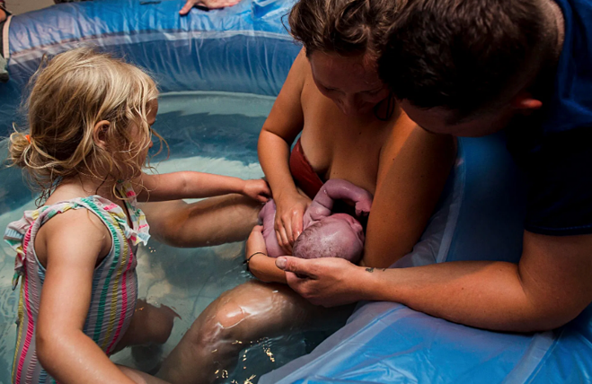 Hình ảnh River nắm tay em bé mới sinh được nhiếp ảnh gia Corneli Fleur chụp lại. Ảnh: New York Post 