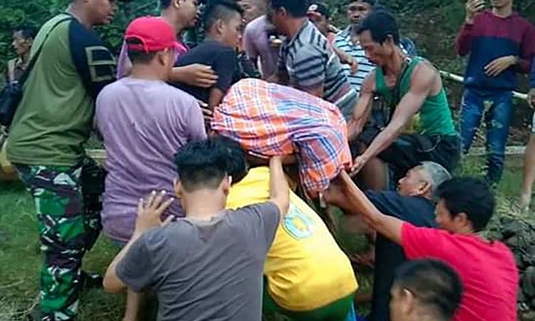 Cơ quan Tìm kiếm và Cứu hộ Kendari cùng dân làng di chuyển thi thể nạn nhân bị cá sấu cắn chết ở North Konawe, tỉnh Southeast Sulawesi, Indonesia, hôm nay. Ảnh: AFP.