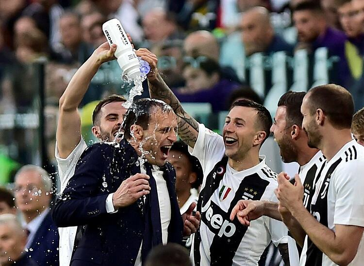 Allegri cùng các cầu thủ ăn mừng khi Juventus lần thứ năm liên tiếp vô địch Serie A. Ảnh: Reuters.