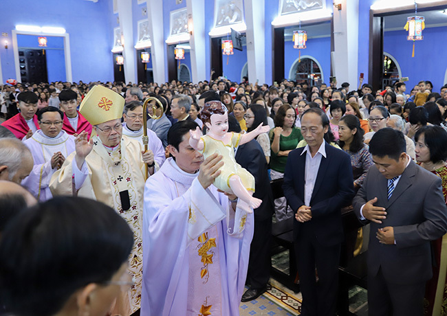 Nghi thức rước tượng Chúa Giêsu hài đồng đặt trong máng cỏ được cử hành trước thánh lễ vọng Giáng sinh. Ảnh: Nguyễn Đông.