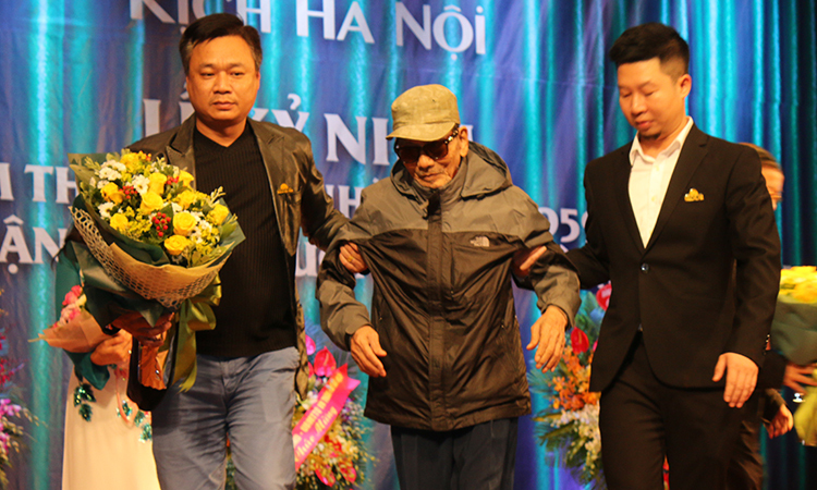 Nghệ sĩ Trần Hạnh được dìu lên sân khấu nhận hoa chúc mừng. Ảnh: Hoàng Huế.