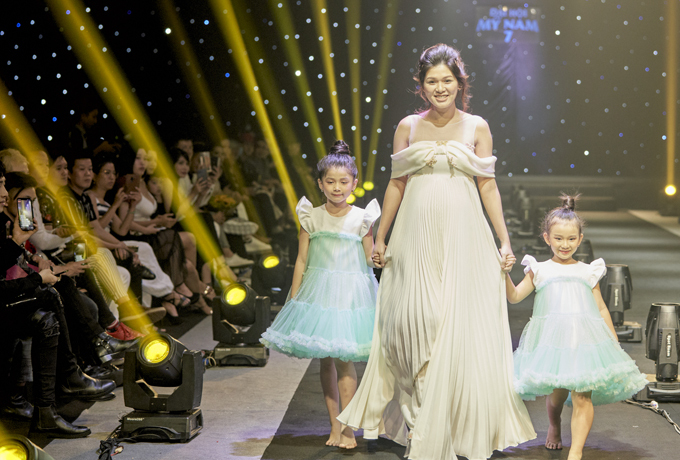 Hoa hậu sải bước cùng hai mẫu nhí. Sự xuất hiện của cô tại Đại hội mỹ nam 7 được khán giả cổ vũ nồng nhiệt. Dự kiến khoảng tháng 3 năm sau Oanh Yến sẽ sinh con thứ sáu. Cô hiện là bà mẹ đông con nhất showbiz Việt.