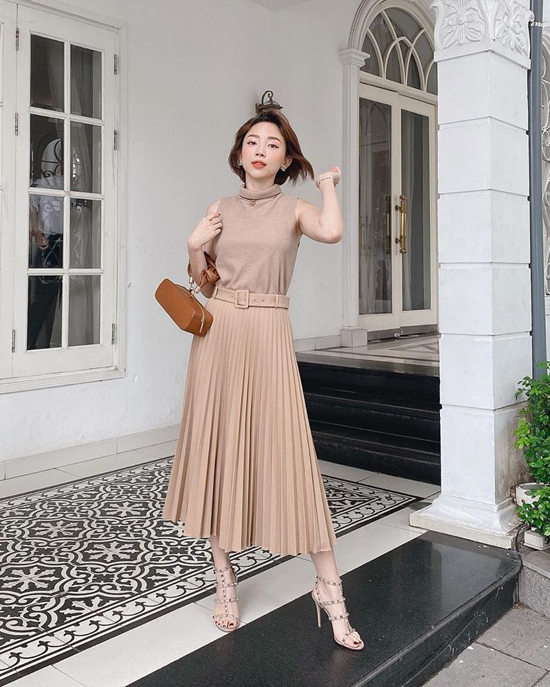 Tóc Tiên với hình ảnh nhẹ nhàng và nữ tính khi phối áo tông nude đồng điệu cùng chân váy midi.Túi xách tông nâu, phom dáng độc đáo được ca sĩ chọn lựa để hoàn thiện set đồ. 
