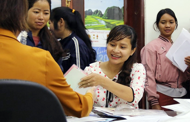 Cô Thanh (giữa) cùng đồng nghiệp đến UBND huyện đối chiếu bằng cấp trước khi nhận quyết định, hôm 19/12. Ảnh: Ngọc Oanh.