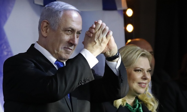 Thủ tướng Israel Benjamin Netanyahu và vợ trong cuộc vận động tranh cử ở thành phố Petah Tikva hôm 18/12. Ảnh: AFP.