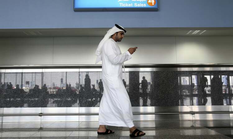 Một người đàn ông dùng điện thoại tại thành phố Dubai, UAE. Ảnh: AP.