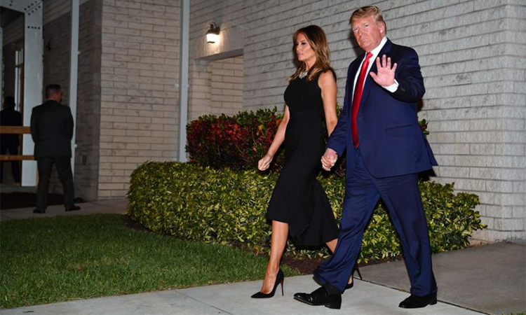 Tổng thống Mỹ và đệ nhất phu nhân Melania rời khỏi nhà thờ Family ở Florida đêm 24/12, sau khi tham dự buổi lễ. Ảnh: AFP.