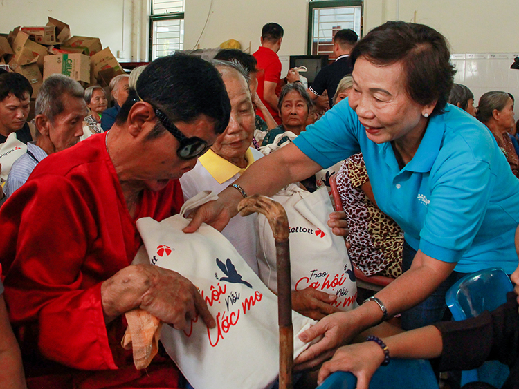 Đại diện Quỹ Hy vọng trao quà cho ông Liêm (áo đỏ, phải) tại Mái ấm Mây Ngàn chiều 10/1. Ảnh: Thanh Trần