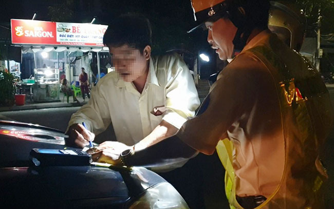 Tài xê Lê Đình Sơn ký vào biên bản vi phạm nồng độ cồn. Ảnh: Đắc Thành.