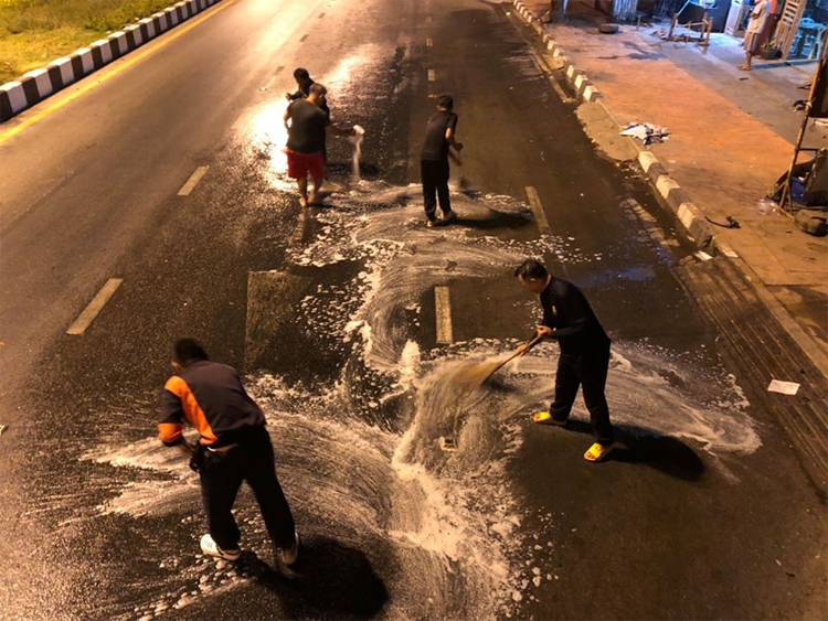 Lính cứu hỏa dọn dẹp hiện trường, lau rửa nhiên liệu trên mặt đường.