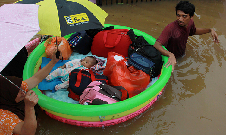 Một em bé được cứu hộ sơ tán bằng phao cứu sinh ở Tangerang, gần Jakarta hôm 1/1. Ảnh: Reuters.