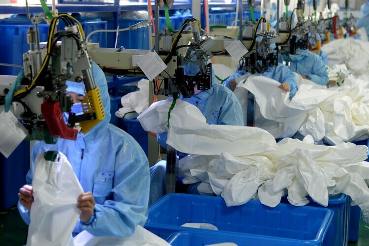 Công nhân làm việc trong một nhà máy sản xuất thiết bị y tế tại Trung Quốc. Ảnh: Xinhua.