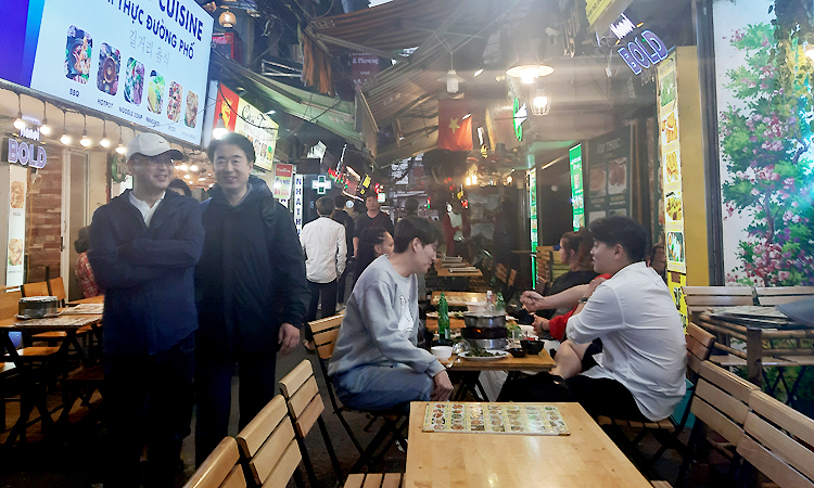 Các quán nhậu bày sẵn bàn ghế, lấn chiếm vỉa hè đón khách tại phố Tạ Hiện, quận Hoàn Kiếm, Hà Nội, trong chiều tối ngày 13/1. Ảnh: Phạm Nga.