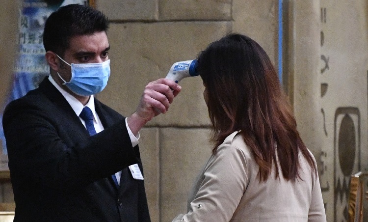 Du khách bị kiểm tra thân nhiệt tại một khách sạn ở Macau, Trung Quốc, hôm 22/1. Ảnh: AFP.