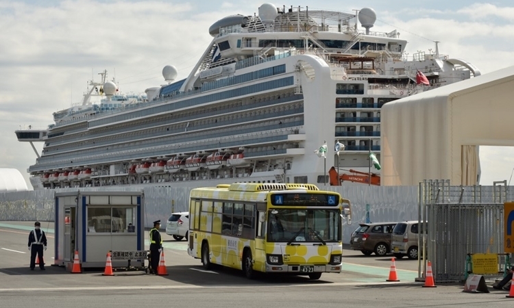 Xe chở hành khách rời khỏi du thuyền Diamond Princess ở Nhật ngày 19/12. Ảnh: AFP.