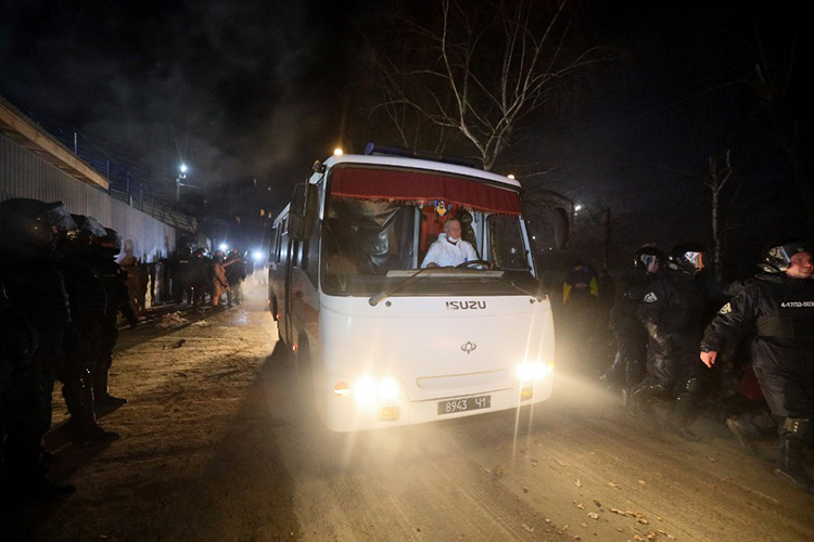 Xe buýt chở hơn 70 người được sơ tán về từ Vũ Hán di chuyển dưới sự bảo vệ của cảnh sát tại làng Novi Sanzhary, vùng Poltava, miền trung Ukraine, hôm qua. Ảnh: AFP