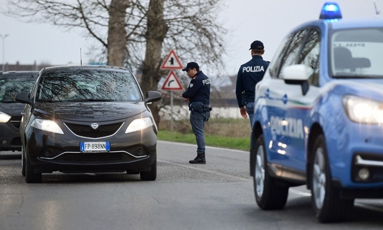 Cảnh sát kiểm tra một chiếc xe tại lối vào thị trấn Casalpusterlengo, đông nam thành phố Milan, Italy, ngày 23/2. Ảnh: AFP.