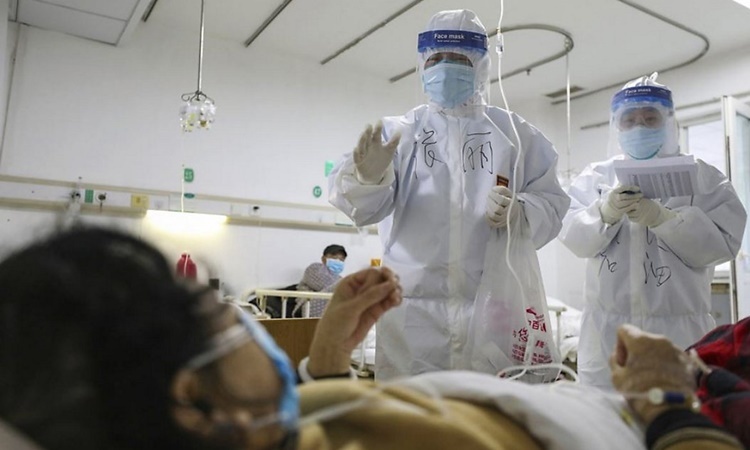 Nhân viên y tế kiểm tra sức khỏe cho một bệnh nhân nhiễm nCoV tại bệnh viện Kim Ngân Đàm ở Vũ Hán. Ảnh: AFP.