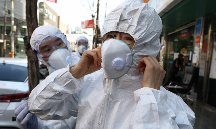 Nhân viên y tế Hàn Quốc đeo khẩu trang trước khi phun thuốc khử trùng ở Seoul ngày 27/2. Ảnh: Chung Sung-jun.