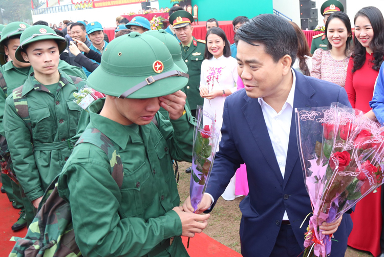 Chủ tịch UBND TP Hà Nội Nguyễn Đức Chung tặng hoa, động viên các thanh niên nhập ngũ. Ảnh; Võ Hải.